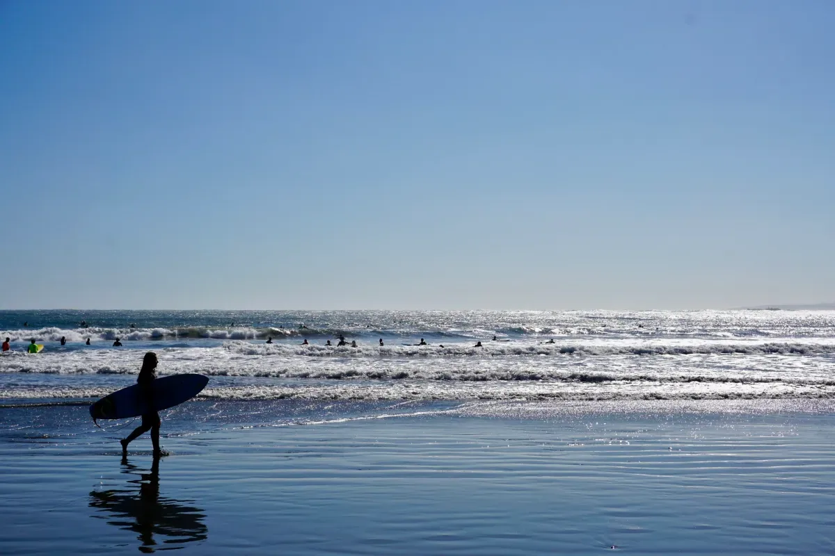 Mar de Concón con surfistas y horizonte luminoso